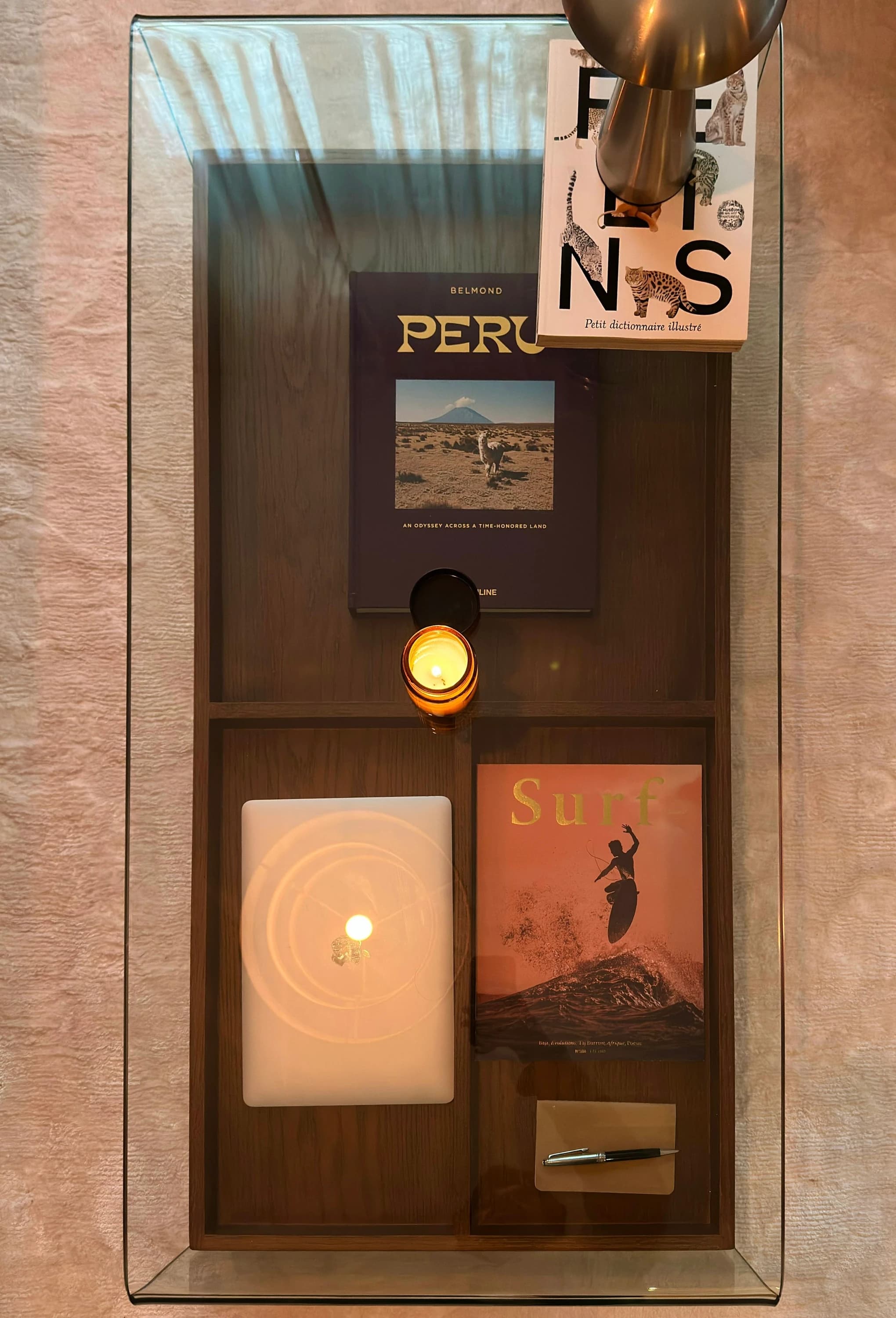 Table basse en verre vue de dessus, livres et objets de décoration, appartement rue Ordener, Paris 18ᵉ